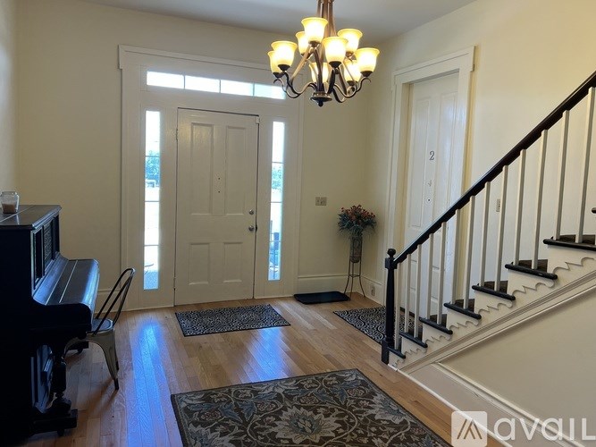 A living room with a piano and a staircase.