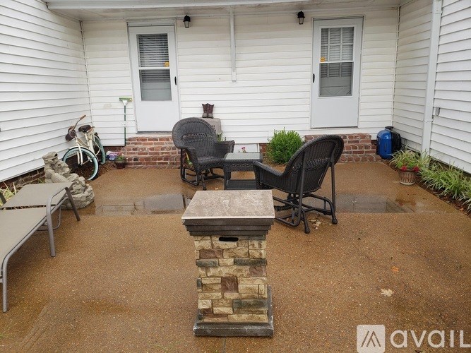 A patio with a table, chairs, and a fireplace.