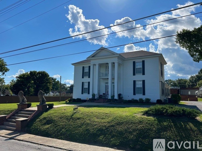 A white house with a blue sky and clouds in the background.