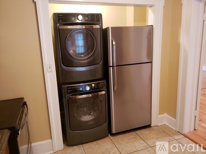 A black dishwasher and a black oven are stacked on top of each other.