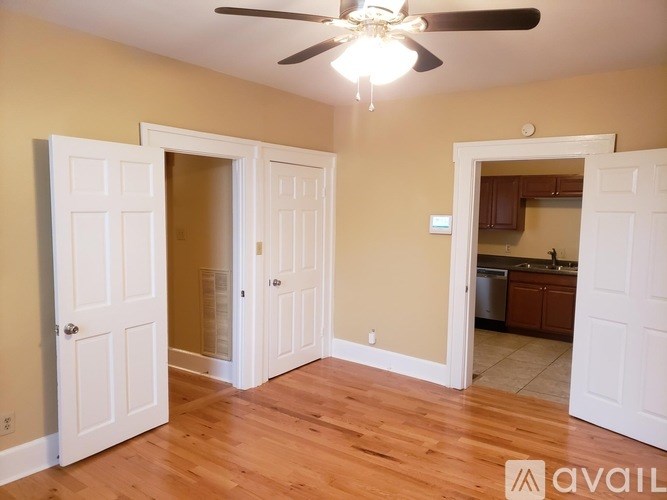 A room with a ceiling fan and wooden floors.