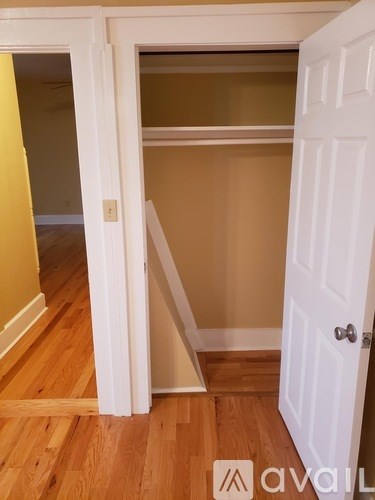 A white door is open to a room with a brown wall.