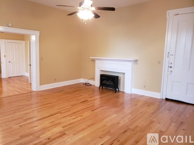 A room with a fireplace and a ceiling fan.