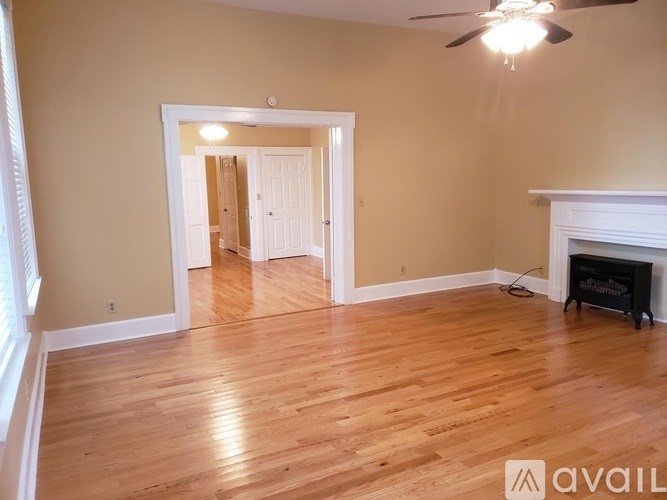 A room with wooden floors and a fireplace.