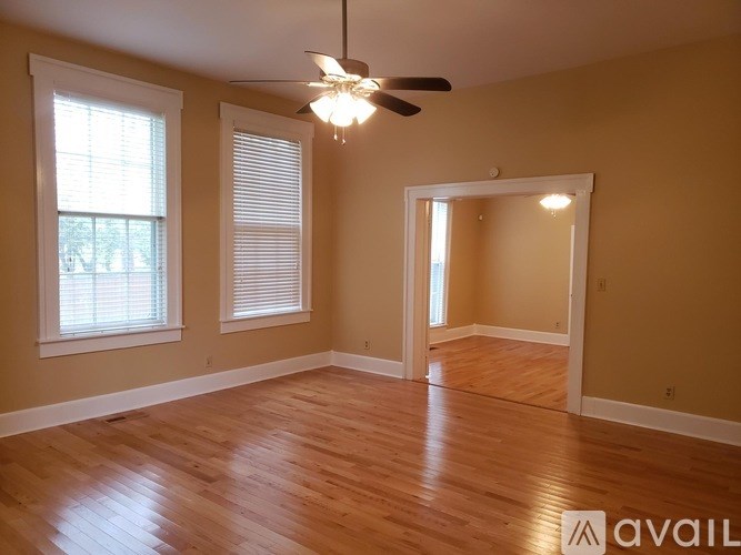 A room with wooden floors and a ceiling fan.