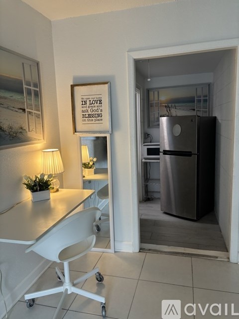 A kitchen with a fridge, table and chairs.