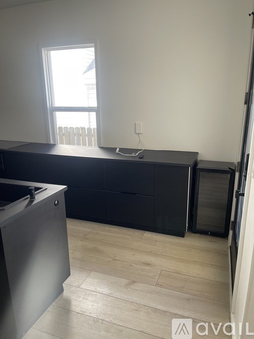 A kitchen with a black countertop and a window.