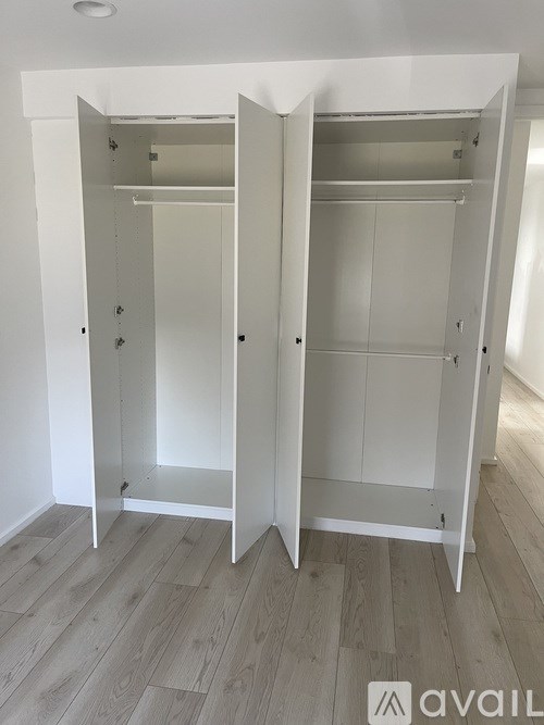 A white wardrobe with two doors is open.