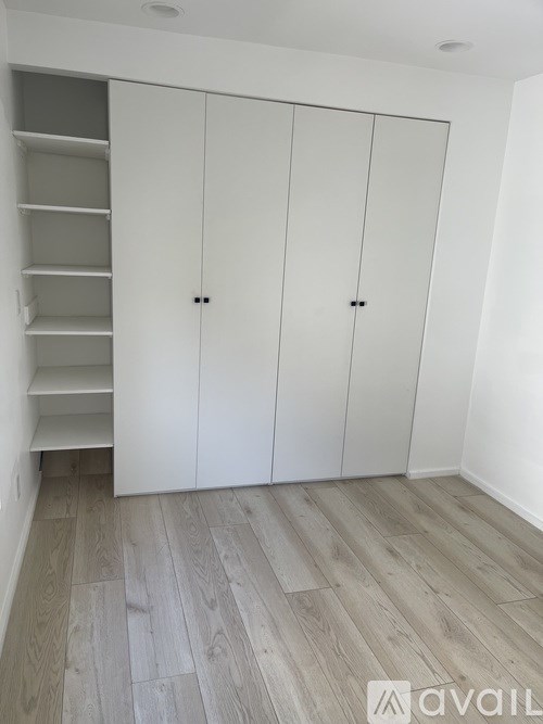 A room with a white cabinet and a grey floor.