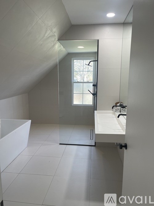 A bathroom with a walk-in shower and a window.