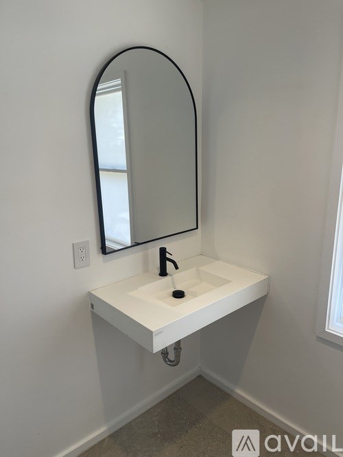 A bathroom sink with a round mirror above it.