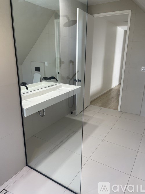 A bathroom with a white sink and a large mirror.