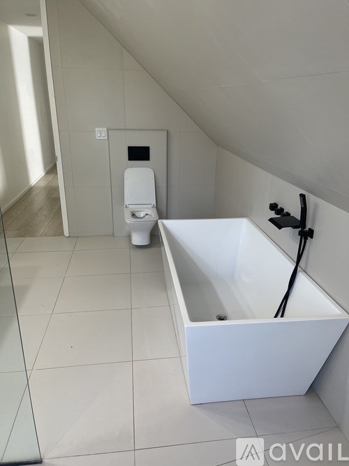 A white bathroom with a toilet and a bathtub.