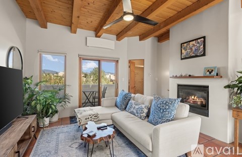 A living room with a white couch and a fireplace.