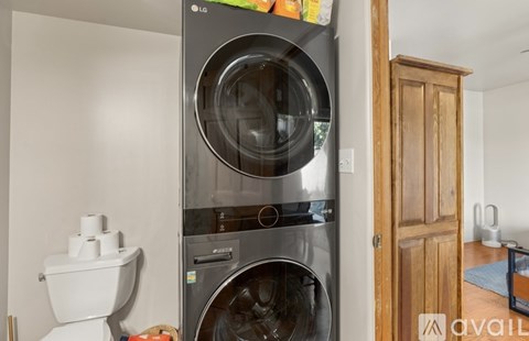 A modern LG dishwasher is placed next to a toilet in a kitchen.