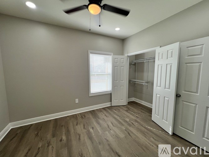A room with a ceiling fan and a door leading to another room.