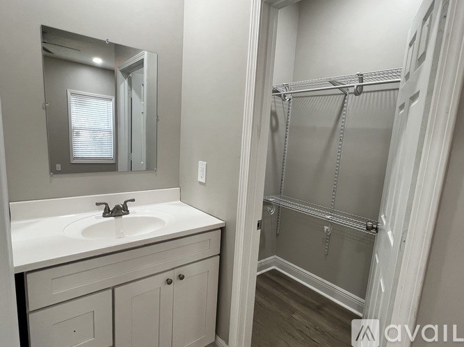 A bathroom with a sink, mirror, and shower.