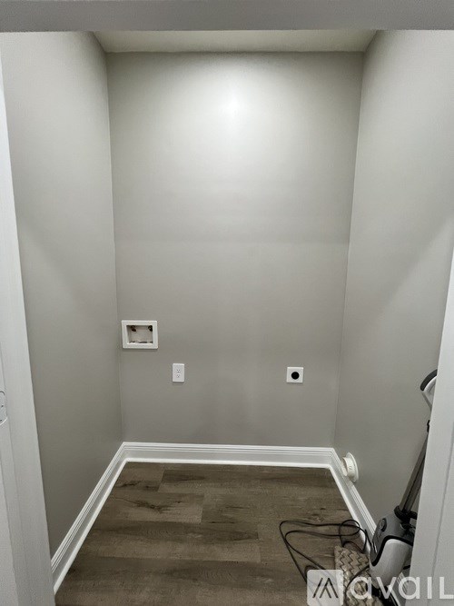 A room with a light switch and a power outlet on the wall.