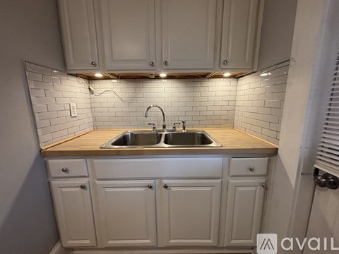 A kitchen with white cabinets and a wooden countertop.