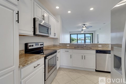 A kitchen with white cabinets and a granite countertop.