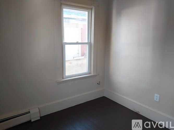 A room with a window and a radiator on the wall.