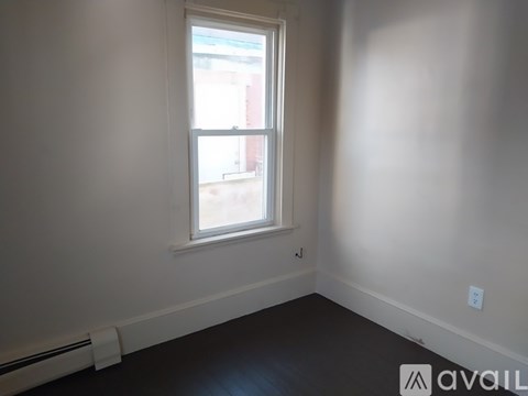 A room with a window and a radiator on the wall.