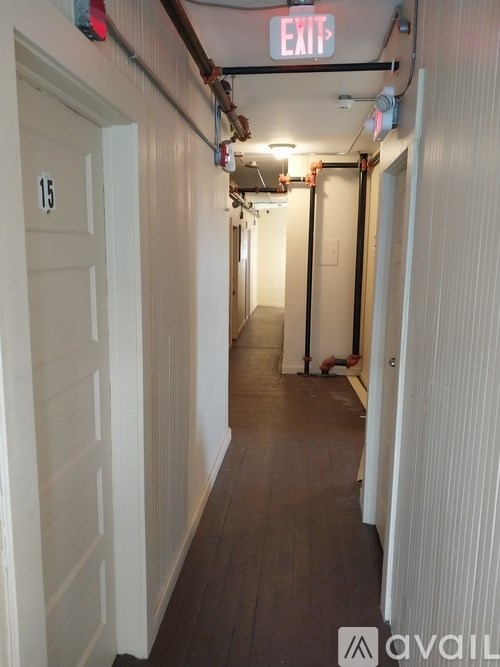 A long hallway with a red exit sign at the top.