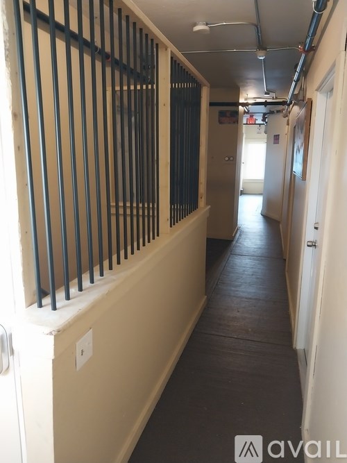 A long hallway with a metal railing on the left and doors on the right.