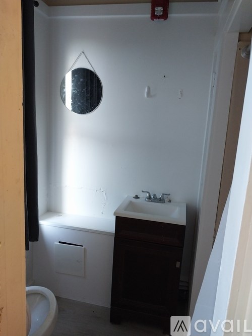 A bathroom with a toilet, sink, and mirror.