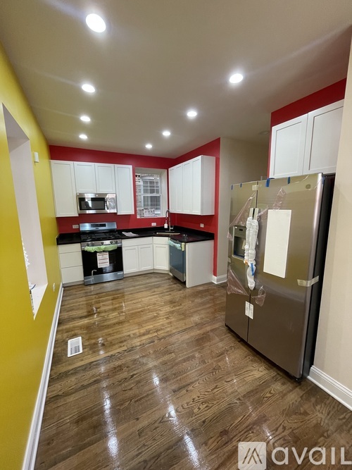 A kitchen with a refrigerator, microwave, and oven.