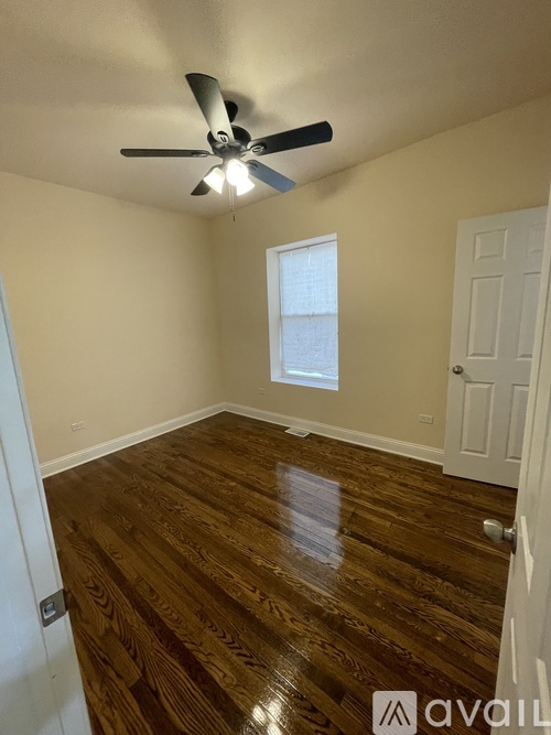 A room with a ceiling fan and wooden flooring.