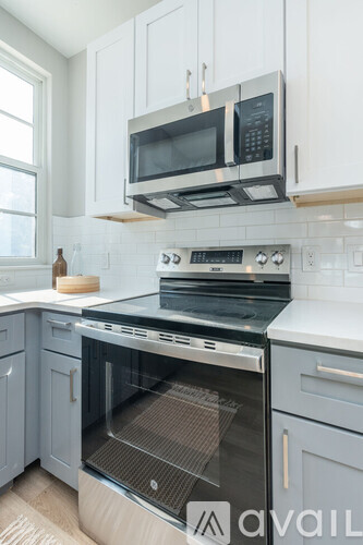 A modern kitchen with a stove top oven and microwave above it.