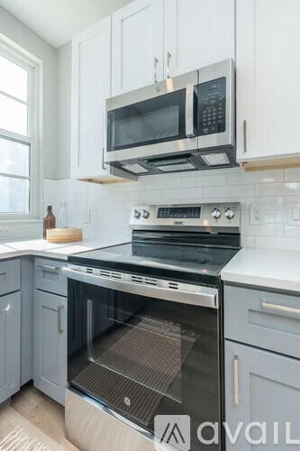 A modern kitchen with a stove top oven and microwave above it.
