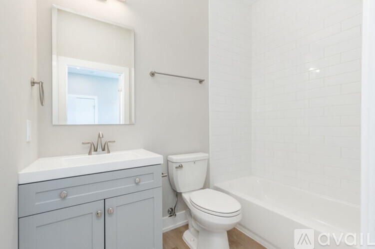 A white toilet sits next to a white sink in a bathroom.