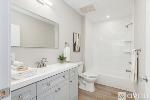 A bathroom with a white toilet, sink, and bathtub.