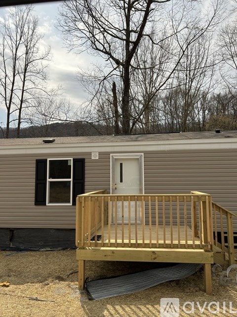 A small house with a wooden deck in front.