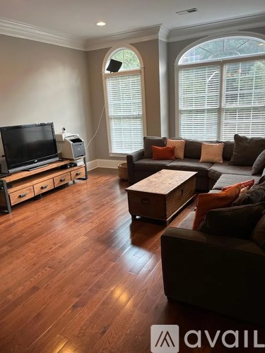 A living room with a brown couch and a television.