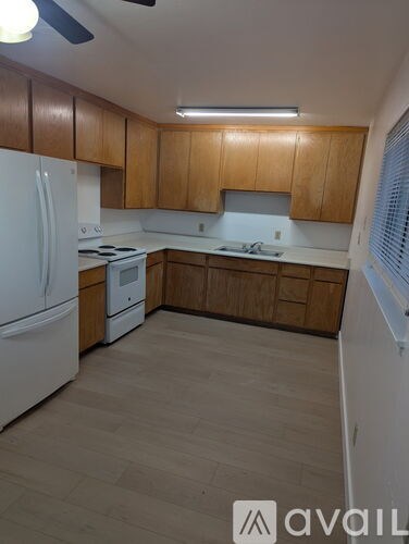 A kitchen with wooden cabinets and a white refrigerator.