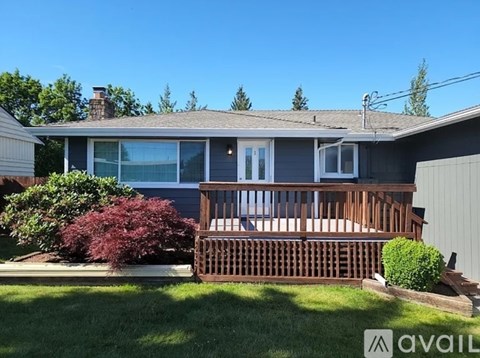 A house with a grey roof and a wooden deck.