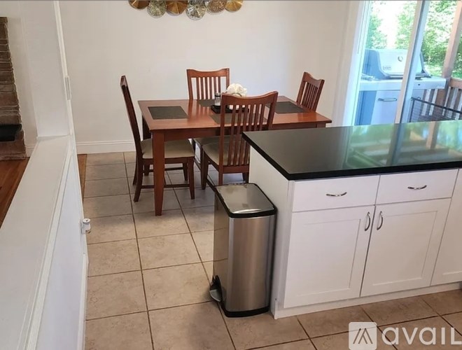 A kitchen with a dining table and chairs.