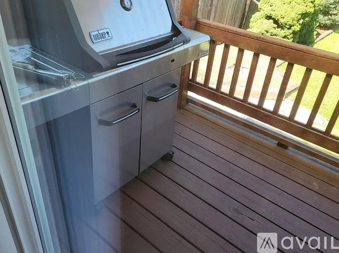 A stainless steel dishwasher is on a wooden deck.