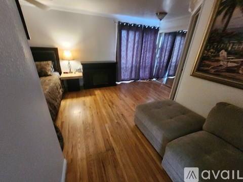 A living room with a grey couch and a wooden floor.