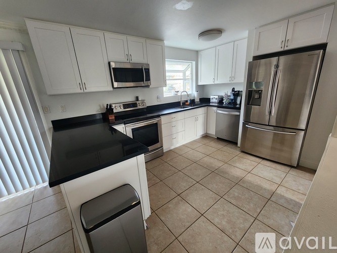 A kitchen with black countertops and white cabinets.