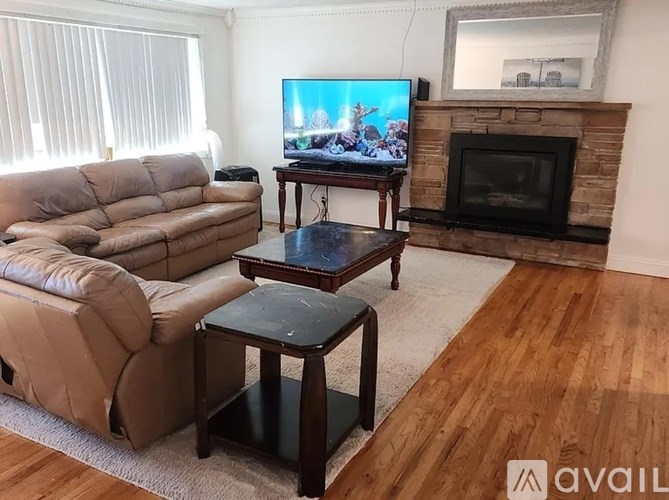 A living room with a couch, a chair, a coffee table, and a television.
