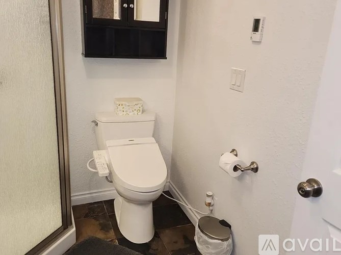 A white toilet with a white tank and a white toilet paper holder.