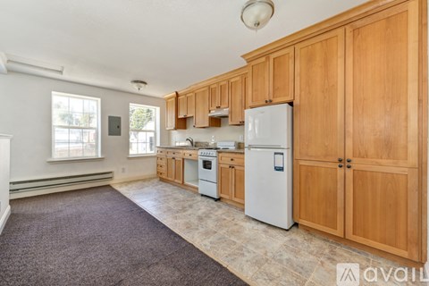 A kitchen with wooden cabinets and a white refrigerator.