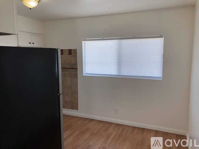 A black refrigerator in a room with a window.
