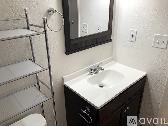 A bathroom with a white sink and a towel rack.