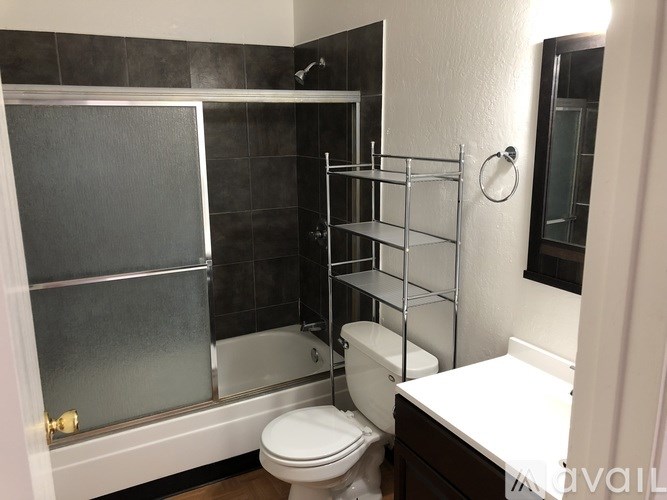 A bathroom with a toilet, a walk-in shower, and a towel bar.