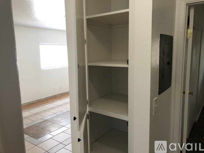 A white closet with shelves is open.